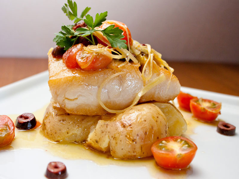 backed fish on roasted potatoes with cherry tomatoes