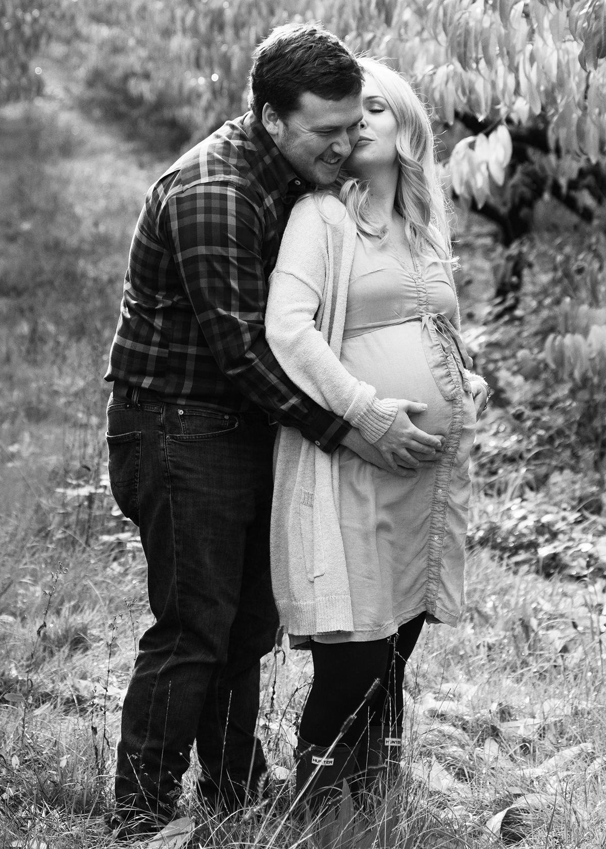 young couple with hubby holding wife's baby bump